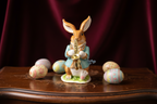 Figurine of a rabbit playing a saxophone on a blue background