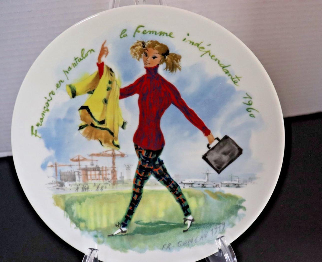 Decorative plate with a stylized illustration of a woman holding a coat and briefcase, set against a scenic background.