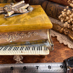 Grand piano music box with amber marbled top, ornate gold-tone detailing and Swiss musical movement