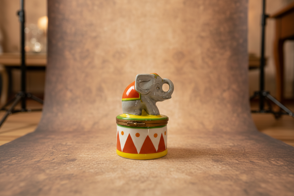 Decorative figurine of an elephant on a circus-themed hat with a white background