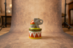 Decorative figurine of an elephant on a circus-themed hat with a white background