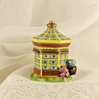 Decorative ceramic pagoda with floral design on a textured beige background