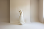 White strapless gown on a mannequin against a white background
