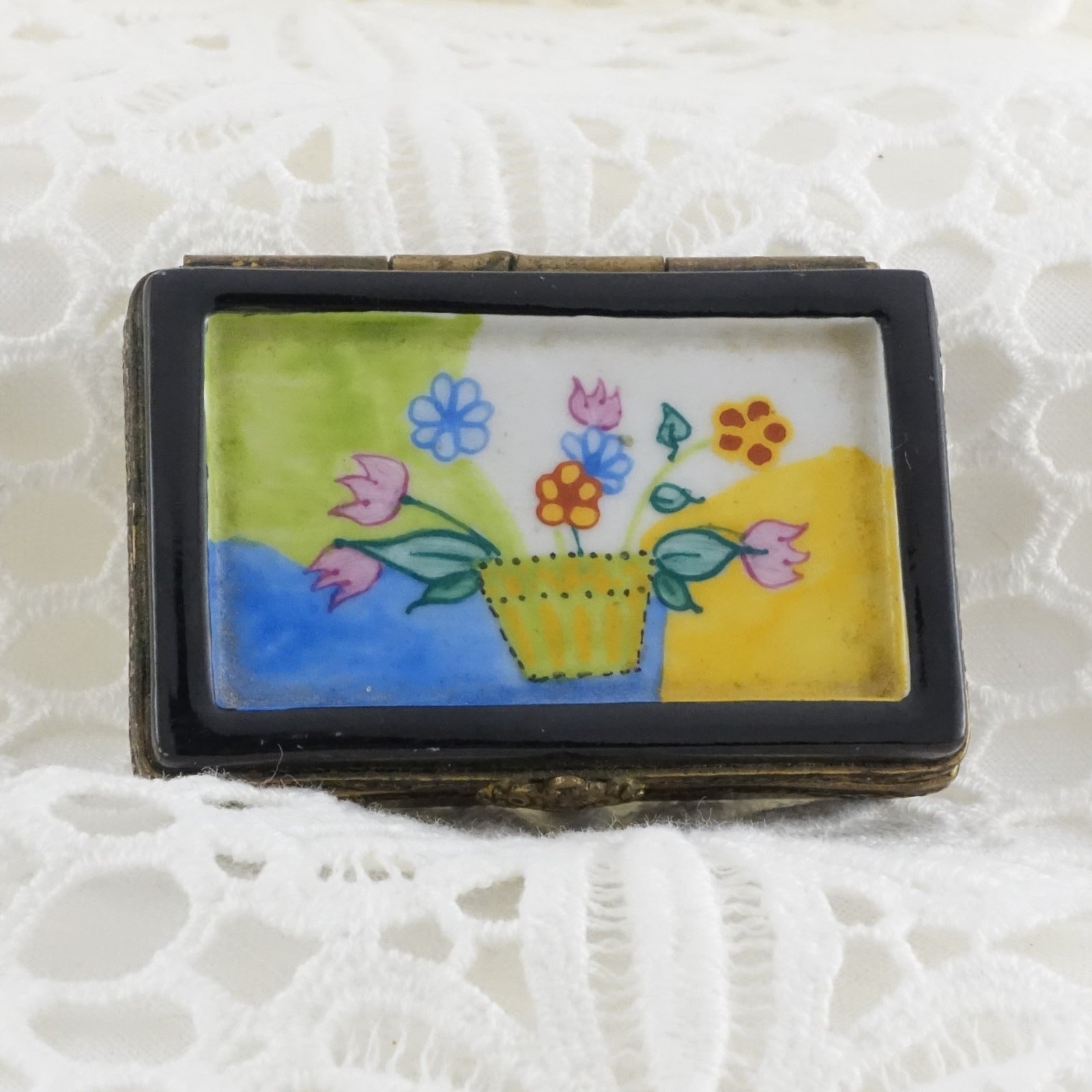 Small rectangular box with floral design on a textured white background