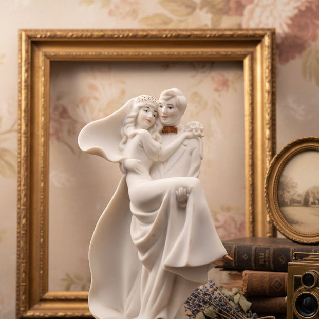 White ceramic figurine of a couple embracing on a black background