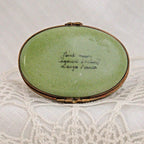 Vintage green compact mirror with gold frame on a lace background