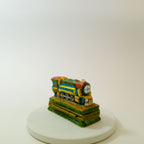 Colorful train-shaped object on a white platform with a white background