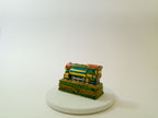 Model of a school bus on a white pedestal against a white background
