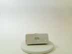 Small electronic device on a white platform with a plain background