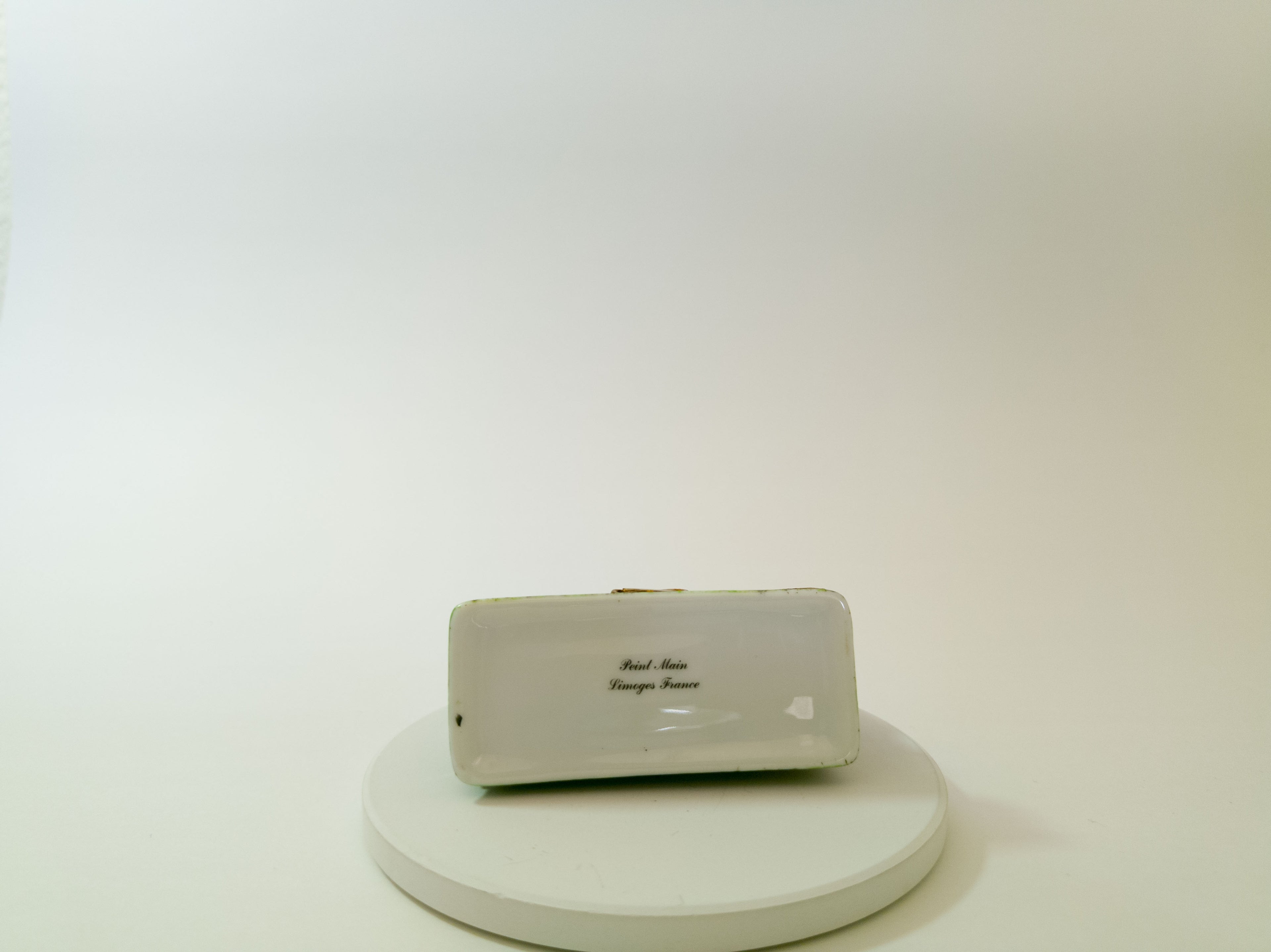 Small electronic device on a white platform with a plain background