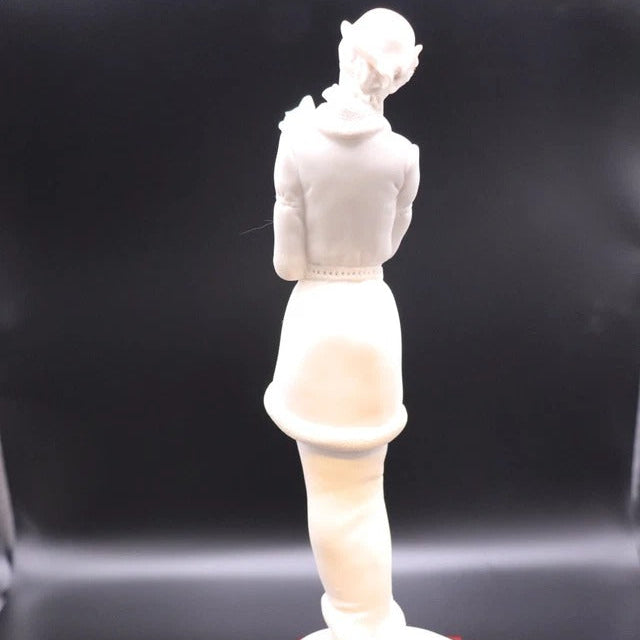 White ceramic figurine on a dark background