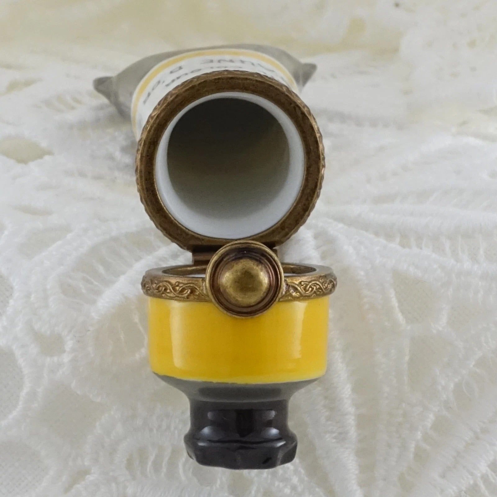 Decorative object with yellow and gold design on a textured white background