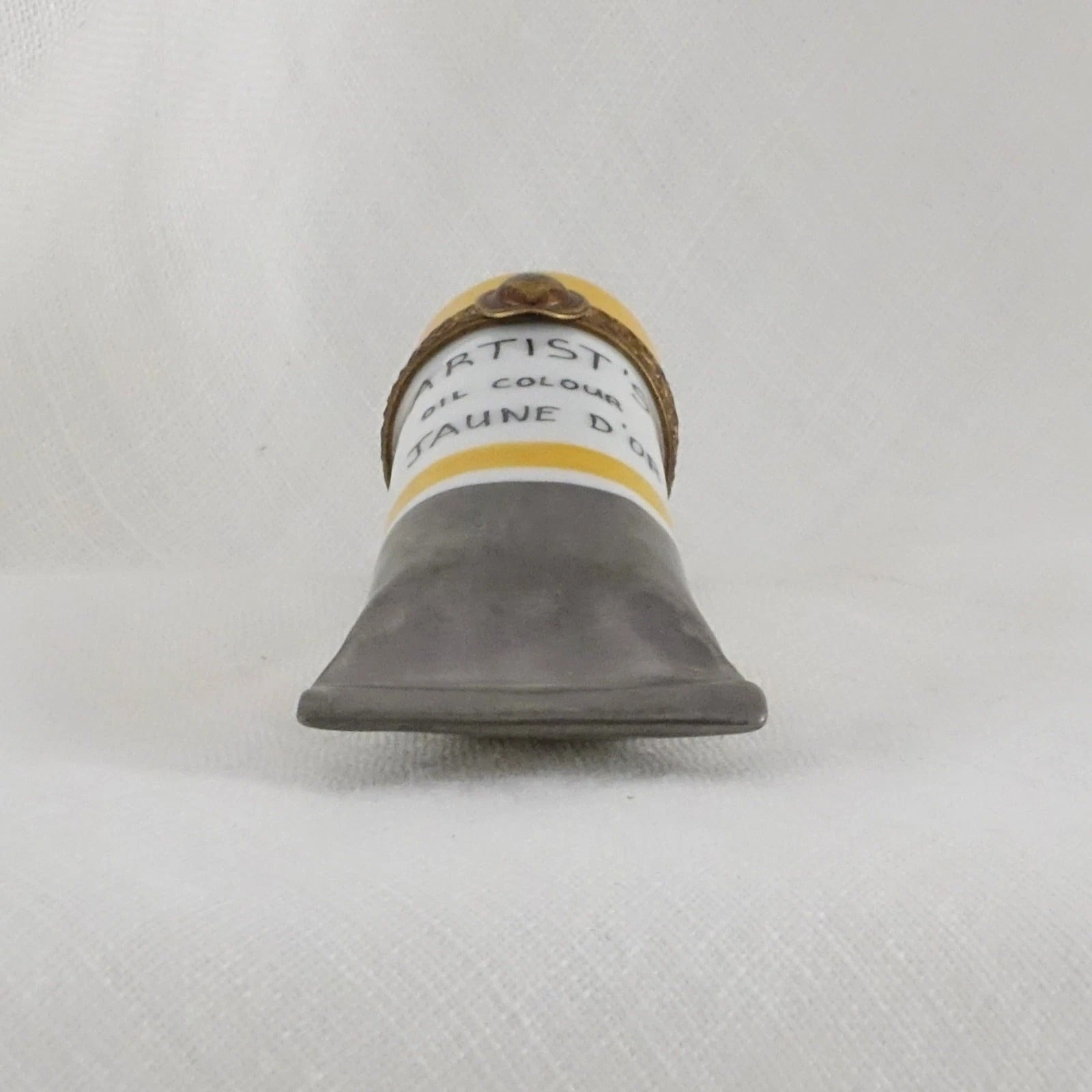 Artiste oil paint tube on a textured gray background