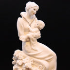 Statue of a woman holding a child on a black background
