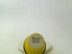 Small yellow cupcake with a white circle and text on a white background