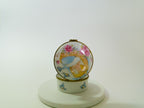Decorative ceramic pot with floral and bird design on a white background