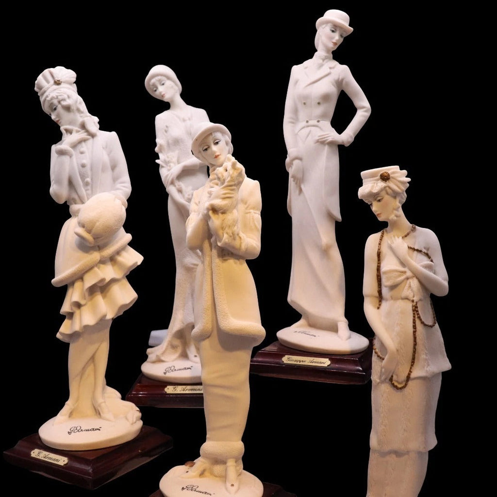Set of six white ceramic figurines on black background