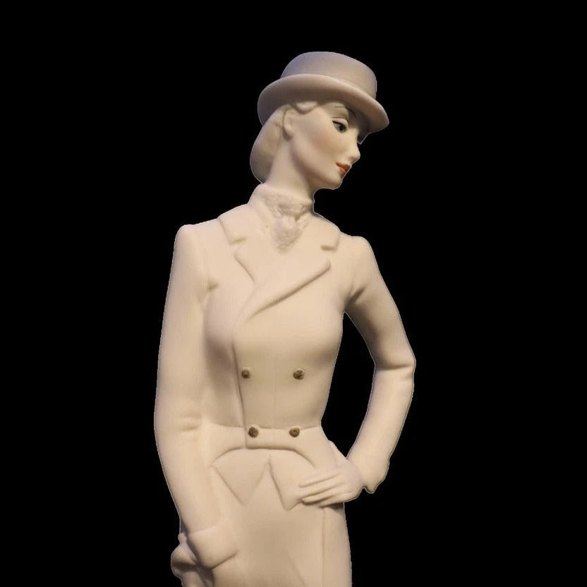 White ceramic figurine of a woman in formal attire with a hat on a black background