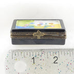 Decorative box with floral design on a white background, next to a ruler for scale.