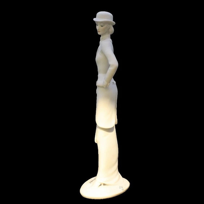 White ceramic figurine of a woman wearing a hat on a black background