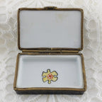 Open jewelry box with a yellow and red heart design on a textured white background