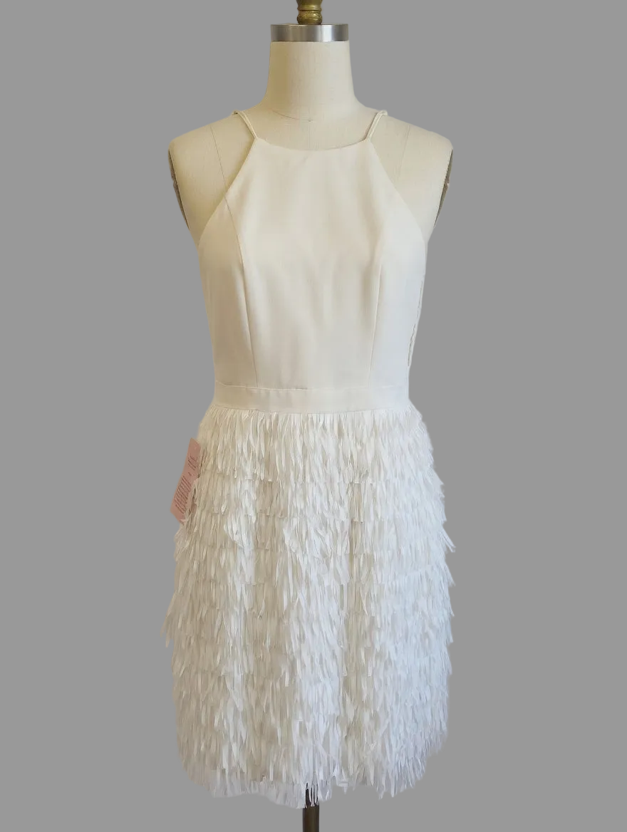 White dress with feathered skirt on a mannequin against a plain background